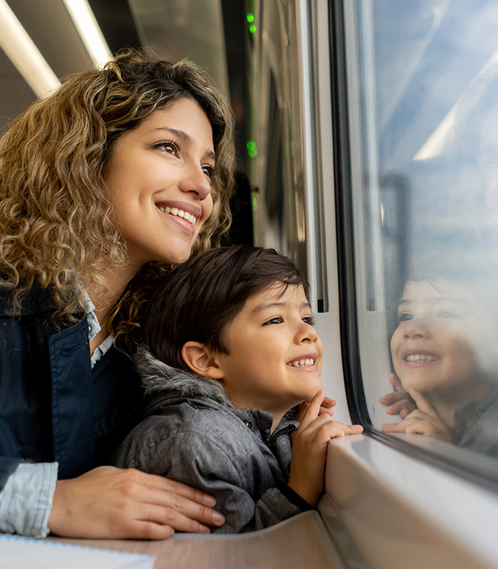 A woman and her son sat on a train looking out the window
