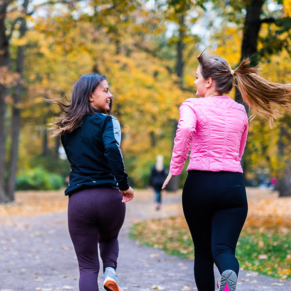 Two women on a run on a path through a park