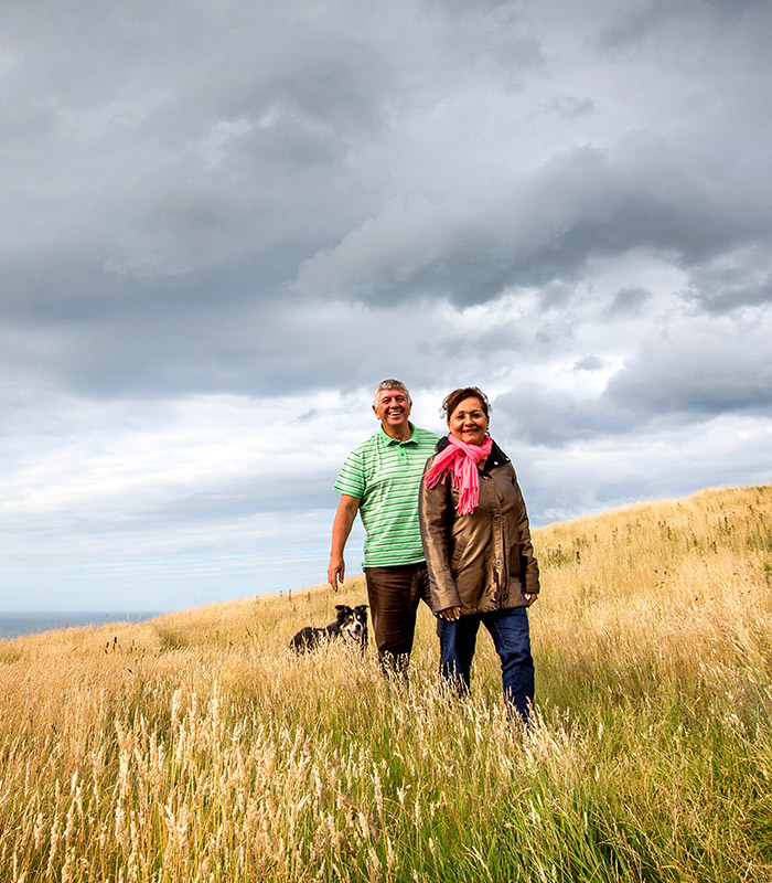 A man and woman walking through a field